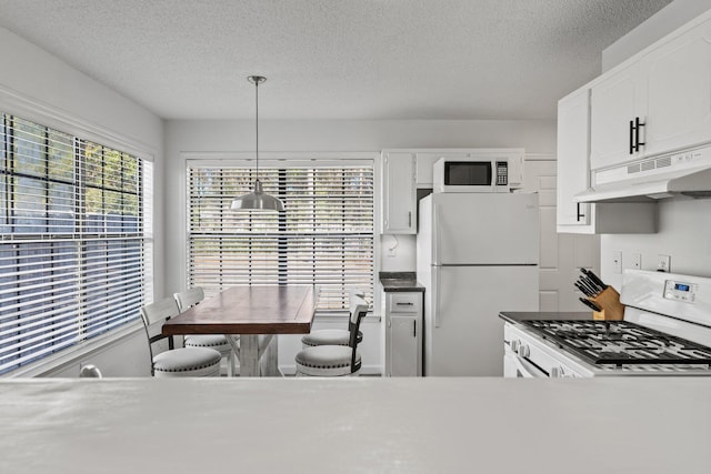 kitchen with white cabinetry, white appliances, a textured ceiling, and pendant lighting