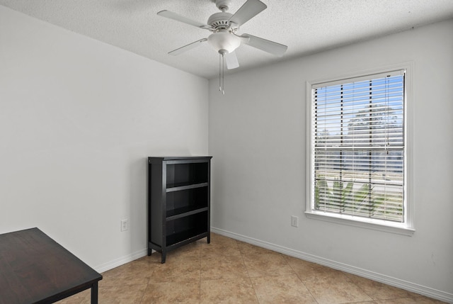 unfurnished room with light tile patterned flooring, ceiling fan, and a textured ceiling