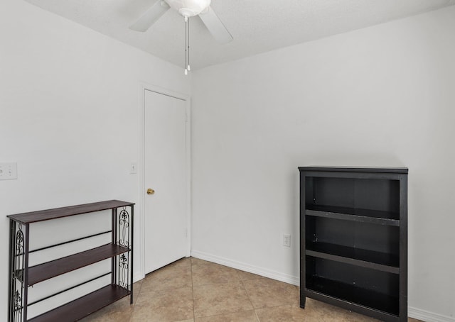 tiled spare room featuring ceiling fan