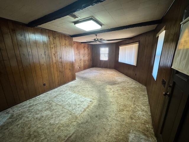 bonus room featuring carpet flooring, beam ceiling, ceiling fan, and wood walls