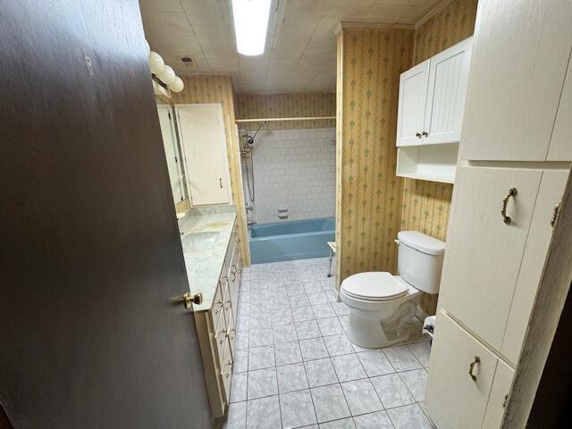 full bathroom featuring tile patterned floors, vanity, tiled shower / bath, and toilet