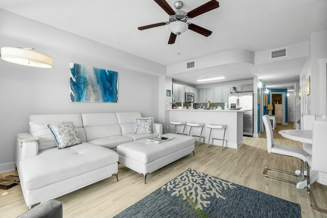 living room featuring ceiling fan and light hardwood / wood-style flooring