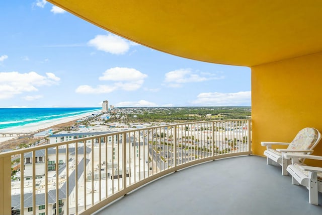 balcony with a water view and a view of the beach