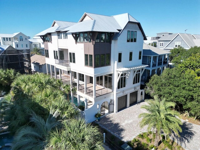 29 Thyme St, Santa Rosa Beach, FL 32459 - rear view of house featuring an attached garage, driveway, a metal roof, and a balcony