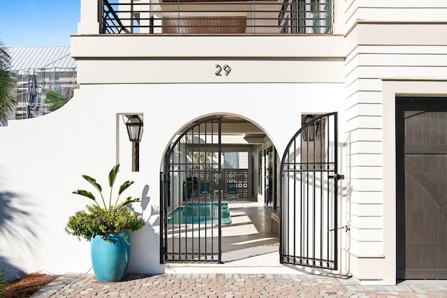 29 Thyme St, Santa Rosa Beach, FL 32459 - doorway to property featuring stucco siding, a balcony, and a gate