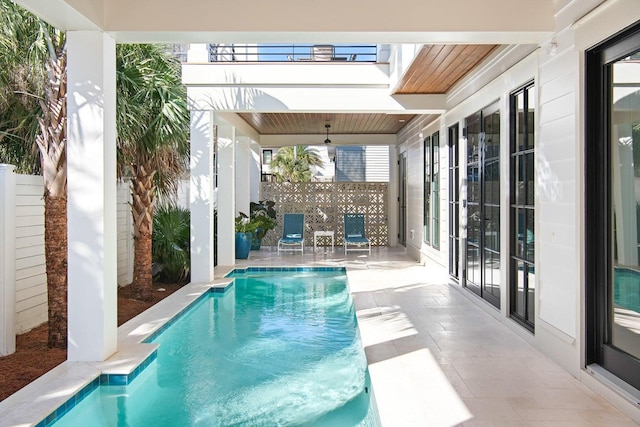 view of swimming pool featuring ceiling fan and a patio area