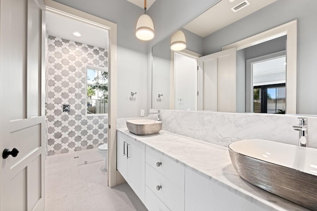 bathroom with tile patterned floors, vanity, tile walls, and toilet