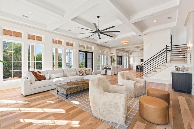 living room with beamed ceiling, wood-type flooring, ceiling fan, and coffered ceiling