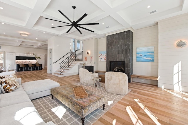 living room with a fireplace, hardwood / wood-style floors, and coffered ceiling