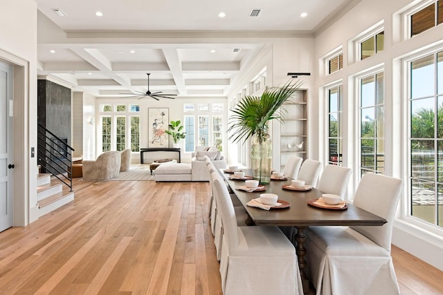 dining room featuring ceiling fan, beamed ceiling, coffered ceiling, and light wood-type flooring