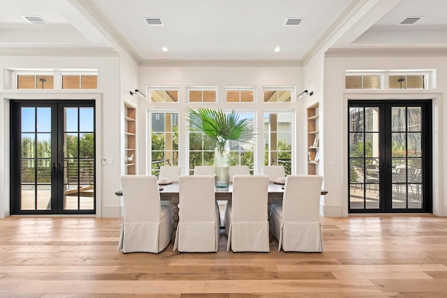 dining room with built in shelves, french doors, plenty of natural light, and ornamental molding