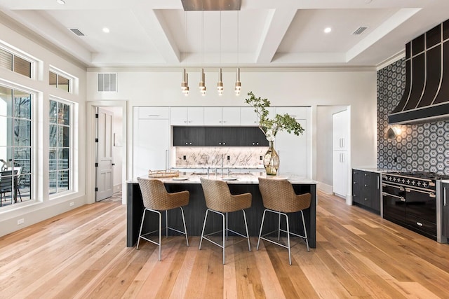 29 Thyme St, Santa Rosa Beach, FL 32459 - kitchen with double oven range, coffered ceiling, a kitchen breakfast bar, dark cabinetry, and decorative backsplash