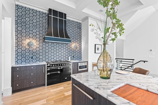 29 Thyme St, Santa Rosa Beach, FL 32459 - kitchen featuring high end range, light wood-style flooring, dark brown cabinets, light stone counters, and wall chimney range hood