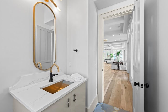 bathroom featuring hardwood / wood-style floors, vanity, and coffered ceiling