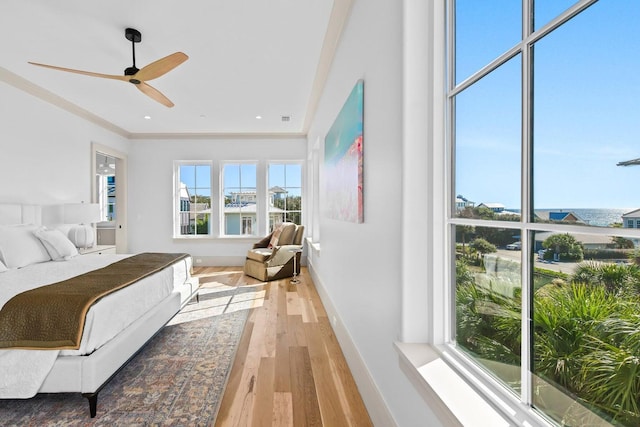 bedroom with ceiling fan, light hardwood / wood-style floors, and ornamental molding