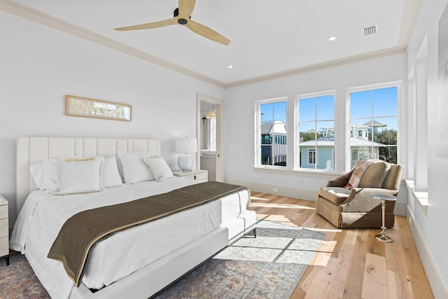 bedroom with light wood-type flooring, ceiling fan, and ornamental molding