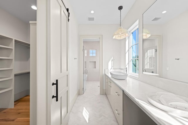 bathroom with vanity, an enclosed shower, and wood-type flooring