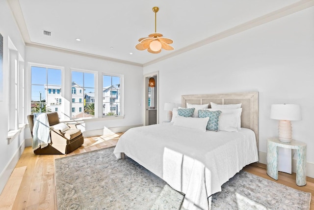 bedroom with light wood-type flooring and ornamental molding