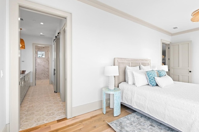 bedroom featuring a barn door and hardwood / wood-style flooring