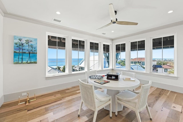 sunroom / solarium with a water view and ceiling fan