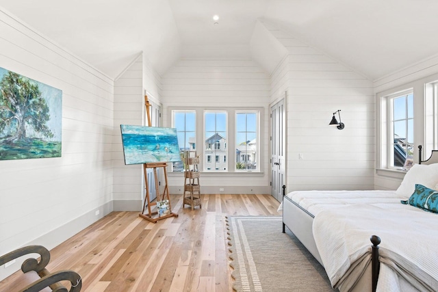 bedroom with multiple windows, light hardwood / wood-style flooring, and vaulted ceiling