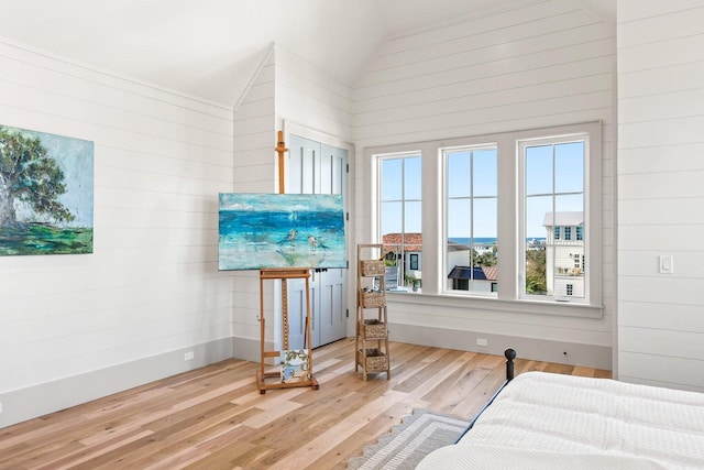 bedroom with wood-type flooring and high vaulted ceiling