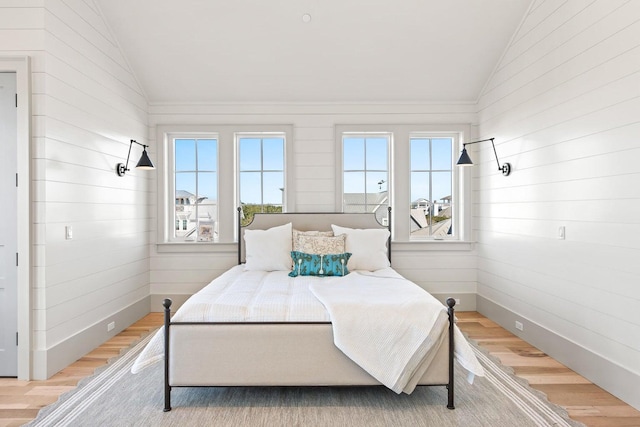 bedroom featuring light hardwood / wood-style flooring and lofted ceiling