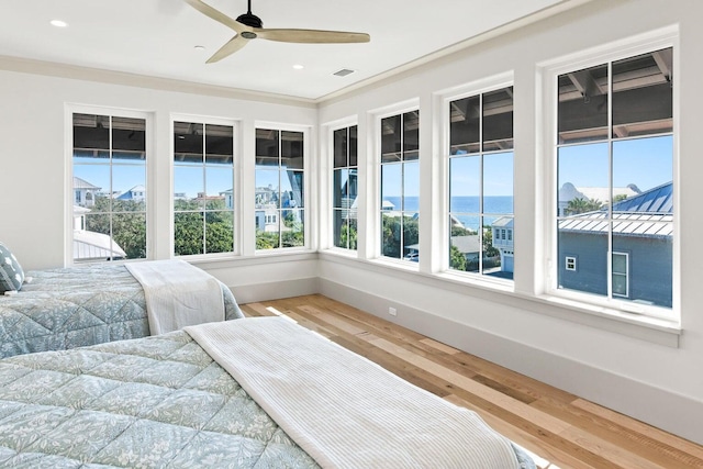 bedroom featuring hardwood / wood-style flooring, ceiling fan, and crown molding