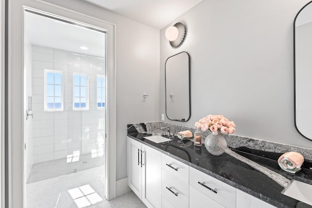 bathroom with vanity and tiled shower