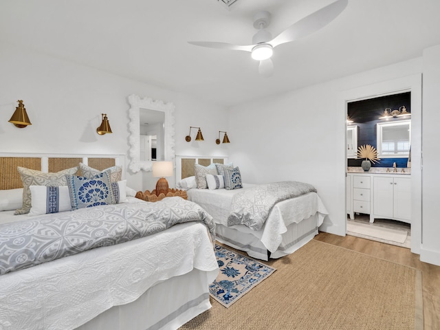 bedroom with ceiling fan, light hardwood / wood-style floors, and sink