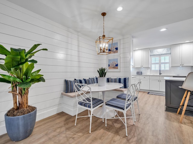 dining space with light hardwood / wood-style floors, an inviting chandelier, breakfast area, and sink