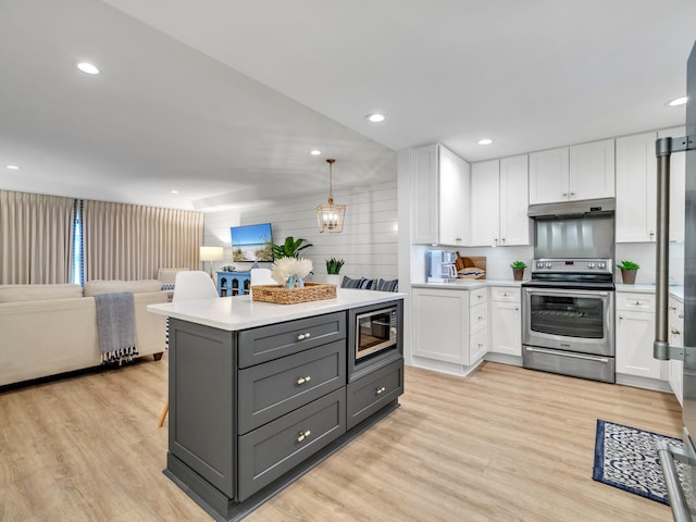 kitchen featuring gray cabinetry, built in microwave, stainless steel range with electric stovetop, white cabinetry, and decorative light fixtures