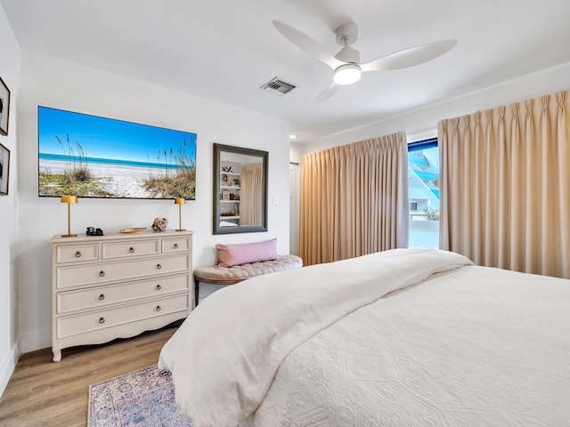 bedroom featuring ceiling fan, light hardwood / wood-style flooring, and multiple windows