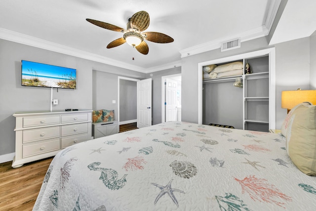 bedroom with ceiling fan, hardwood / wood-style flooring, a closet, and ornamental molding