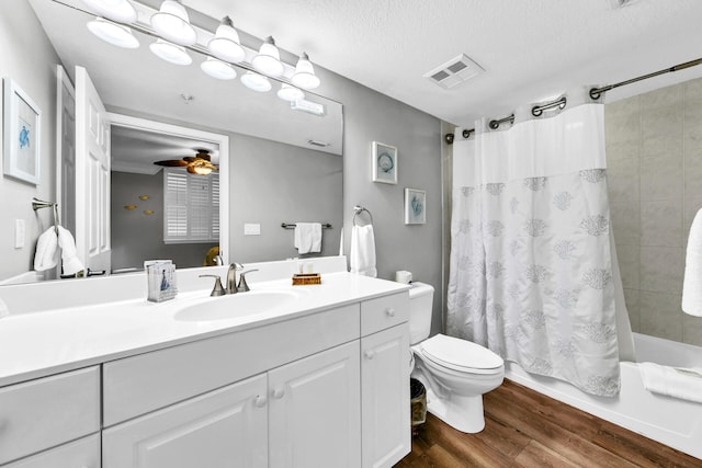 full bathroom with a textured ceiling, hardwood / wood-style floors, vanity, shower / tub combo, and ceiling fan