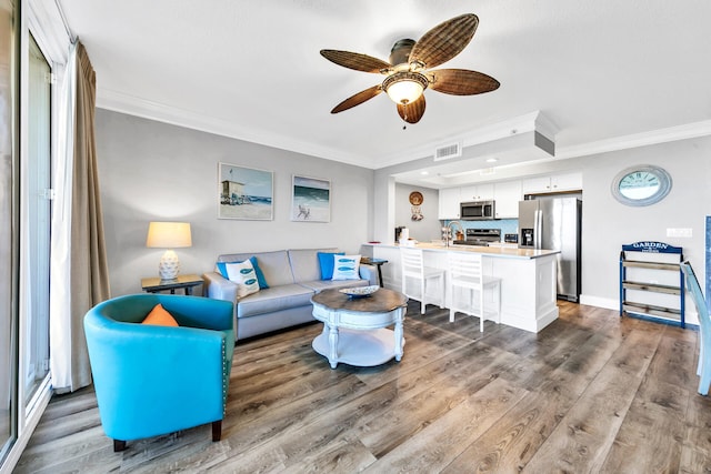 living room with ceiling fan, crown molding, and hardwood / wood-style floors