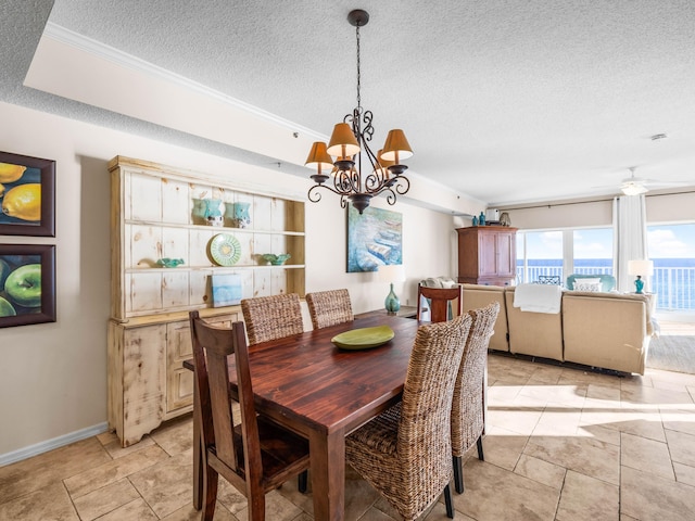 dining room with ceiling fan with notable chandelier and a textured ceiling