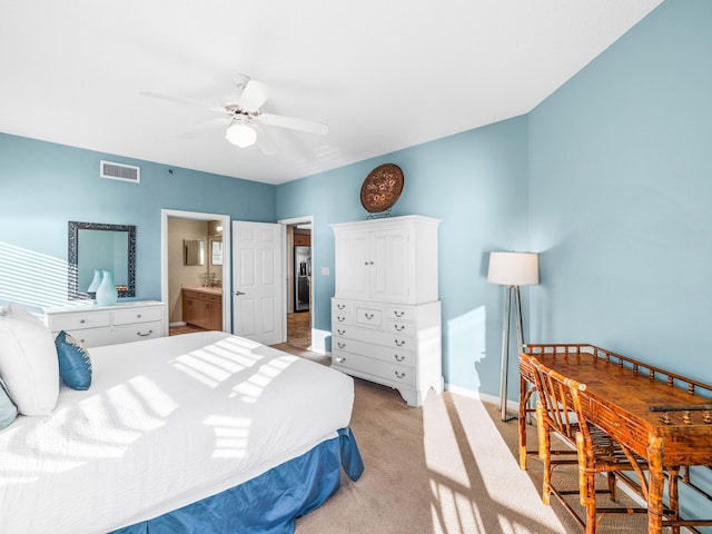 bedroom with light carpet, ensuite bath, and ceiling fan