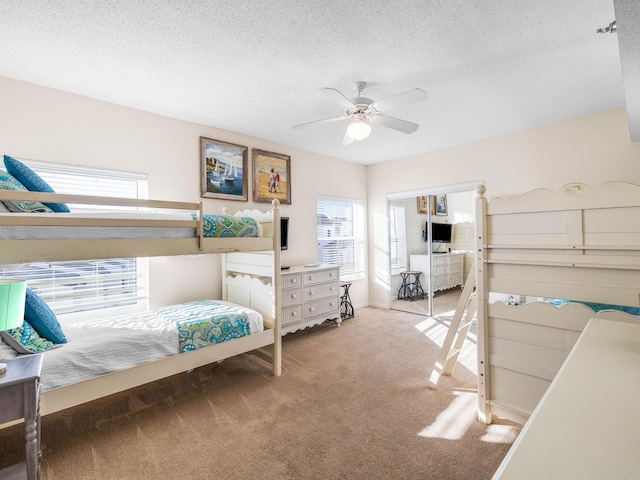 bedroom featuring ceiling fan, carpet, and a textured ceiling