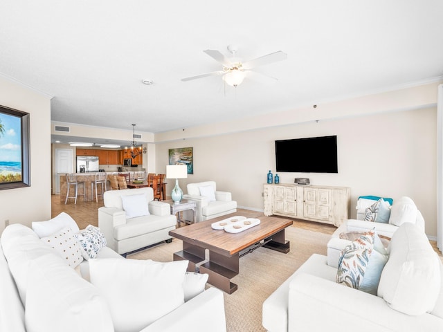 living area featuring baseboards, visible vents, and a ceiling fan