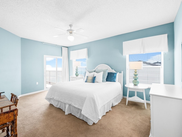 bedroom with a textured ceiling, ceiling fan, baseboards, and light colored carpet