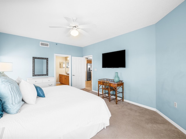 bedroom featuring ensuite bathroom, light carpet, a ceiling fan, visible vents, and baseboards