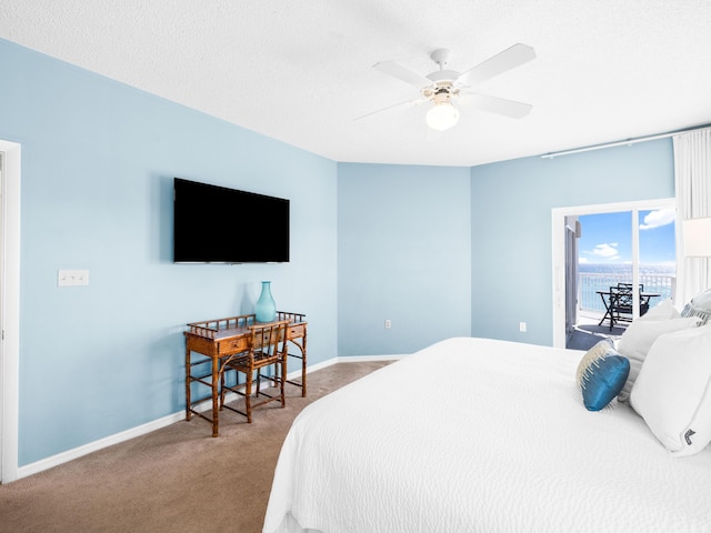 carpeted bedroom with access to exterior, ceiling fan, a textured ceiling, and baseboards