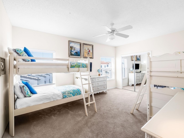 bedroom with carpet floors, a ceiling fan, and a textured ceiling