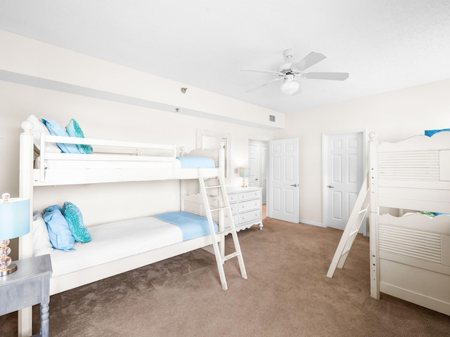 bedroom featuring dark colored carpet, a ceiling fan, and baseboards