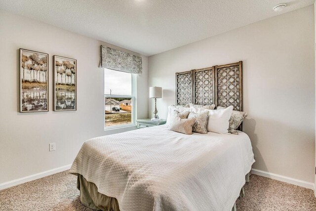 bedroom with a textured ceiling and carpet floors