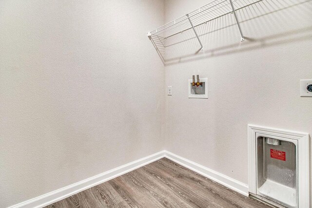 laundry area featuring wood-type flooring, hookup for a washing machine, and electric dryer hookup