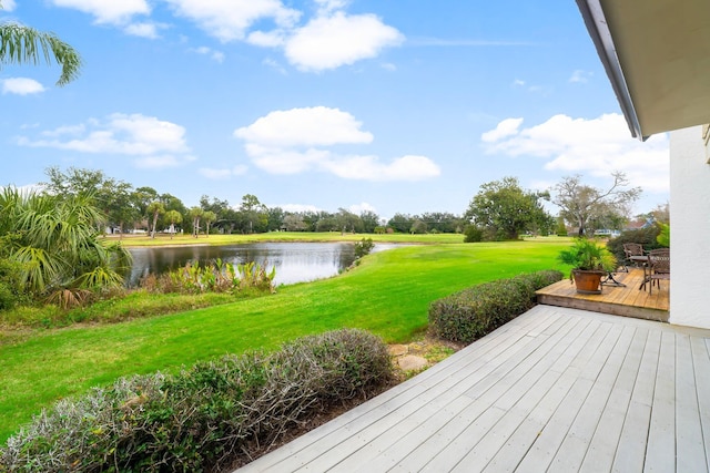 wooden deck with a lawn and a water view