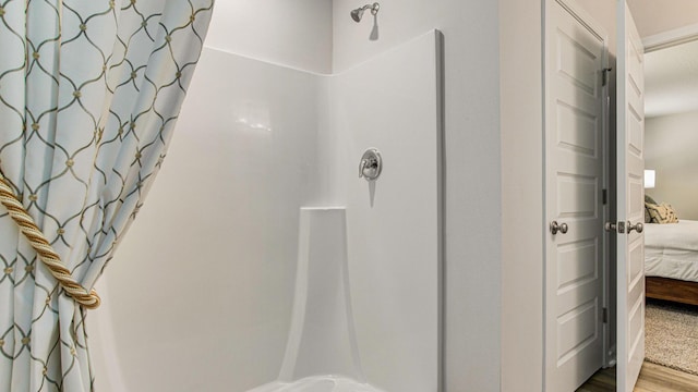 bathroom with a shower with shower curtain and wood-type flooring