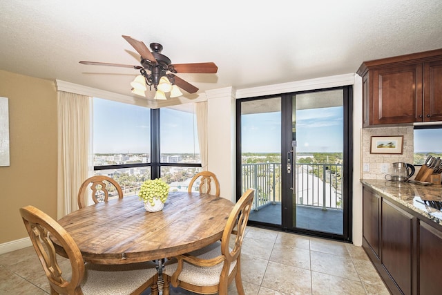 tiled dining area featuring french doors, a wall of windows, and ceiling fan